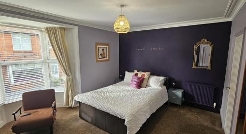a bedroom with a bed and a chair and a mirror at SNUZE Whitby 2 in Whitby