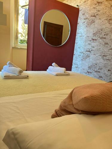 a bedroom with two beds with a mirror on the wall at Villa Sunrise in Lucca