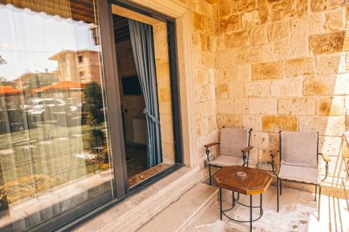 a patio with two chairs and a table on a balcony at Nest Cappadocia Hotel in Uchisar