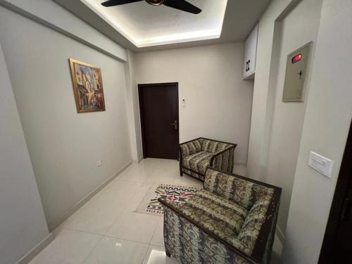 - un salon avec deux chaises et un ventilateur de plafond dans l'établissement Prestige comforts, à Karachi