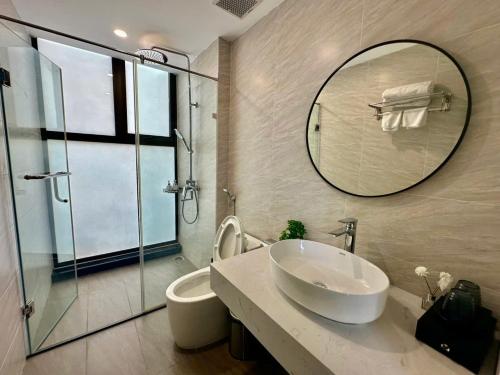 a bathroom with a sink and a mirror and a toilet at Green Villa 5 phòng ngủ ở Flamingo Đại Lải Resort in Phúc Yên