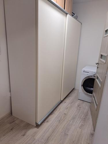 a kitchen with two white refrigerators and a microwave at Moderní apartmán s balkonem v srdci Pardubic in Pardubice