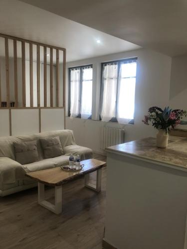 a living room with a couch and a coffee table at Charmant et Lumineux in Caussade