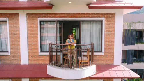a woman standing on a balcony of a house at Temple Himalaya Hotel & Spa in Pokhara