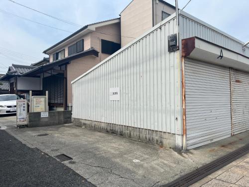 a building with a garage door on the side of it at つなぐ古民家 in Kaizuka
