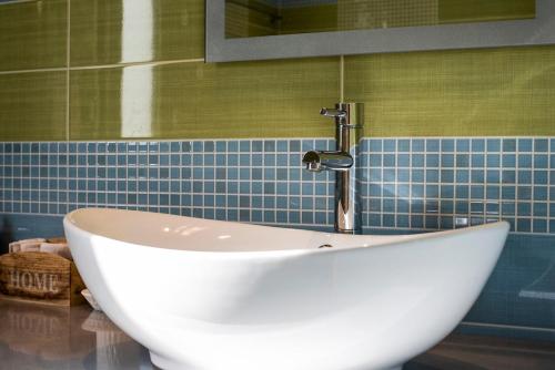 a white sink in a bathroom with blue tiles at Palm Tree Beach Villa in Kakongiónion