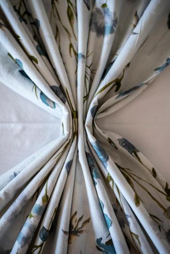 a close up of white curtains with flowers on them at Palm Tree Beach Villa in Kakongiónion