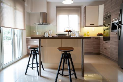 a kitchen with a island with two bar stools at Palm Tree Beach Villa in Kakongiónion