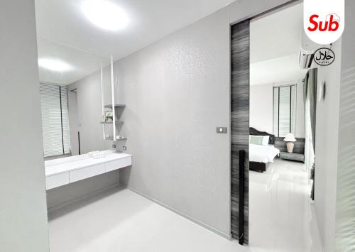a white bathroom with a sink and a mirror at Halal Luxury Villa Near Airport Hat Yai in Ban Thung Ri