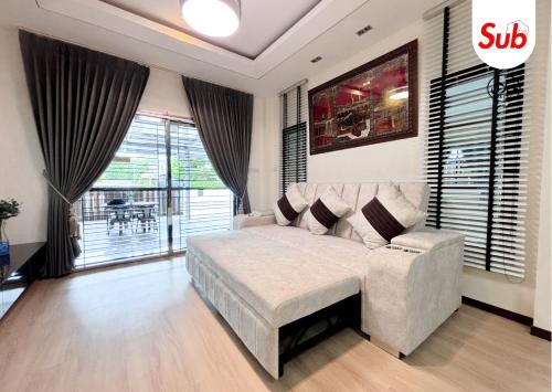 a bedroom with a bed and a couch and a chair at Halal Luxury Villa Near Airport Hat Yai in Ban Thung Ri