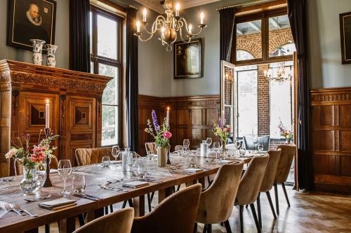 a large dining room with a long table and chairs at Hotel Kasteel Hoekelum in Bennekom