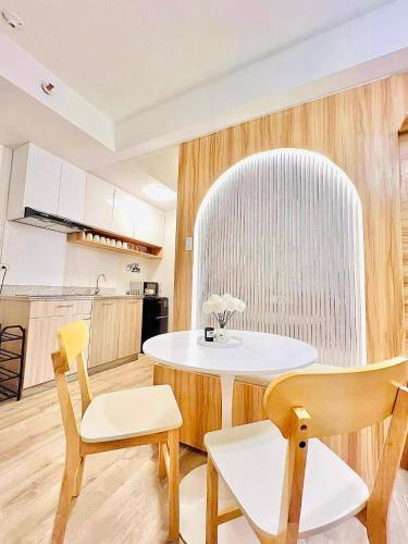 a kitchen with a table and chairs in a room at Reflective Woodscape- 1 Bedroom with Balcony in Bacolod