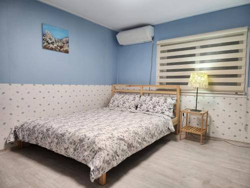 a bedroom with a bed and a blue wall at Mook Seoul in Seoul