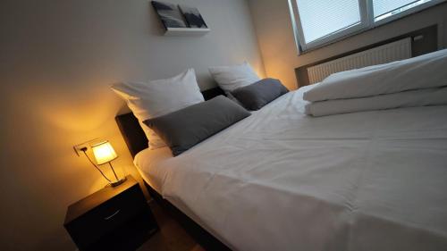 a bedroom with a white bed with a lamp at Ausblick residence in Badenweiler