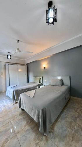 a bedroom with two beds and a chandelier at Nile diana luxor in Luxor