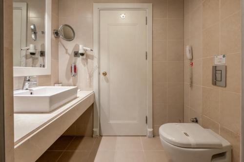 a bathroom with a white toilet and a sink at Fame Residence Kemer & Spa in Kemer