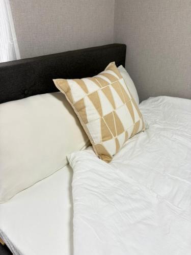 a white bed with a pillow on top of it at 若葉コーポ103 in Fukuoka
