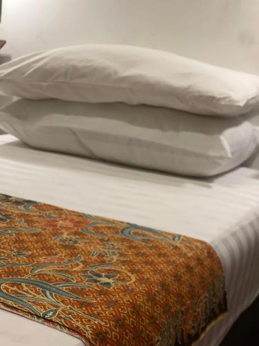 a bed with two pillows and a blanket on it at Heritage House 123 in George Town