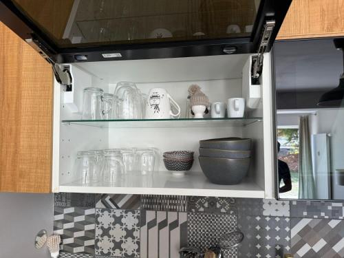 a kitchen with glass jars and bowls on shelves at Verbier Apt 2 rooms in Verbier