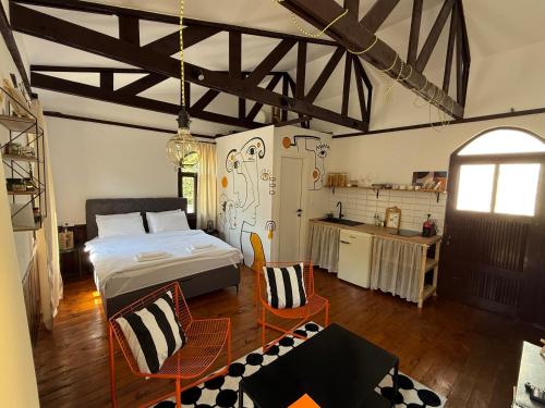 a bedroom with a bed and chairs and a kitchen at Atelje 1981 Apartment in Bijelo Polje