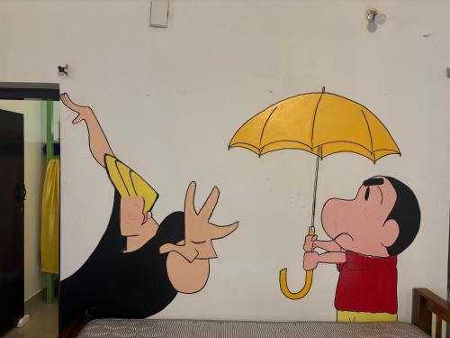 a wall mural of a man holding an umbrella at Yes Hostel Varkala - Black Beach Road in Varkala