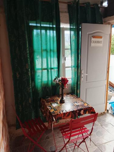a table with red chairs and a vase with flowers on it at Villa des Filaos et du lagon o6, 93 , 70 , 59 , 79 in Saint-Leu