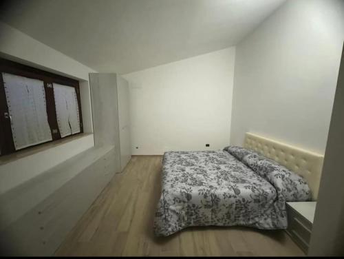 ein Schlafzimmer mit einem Bett in einem weißen Raum in der Unterkunft Appartamento due passi dal mare in Grottammare