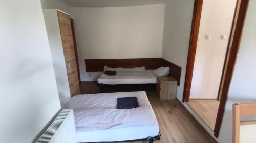 a small room with two beds and a mirror at Dom Narciarza in Szczyrk