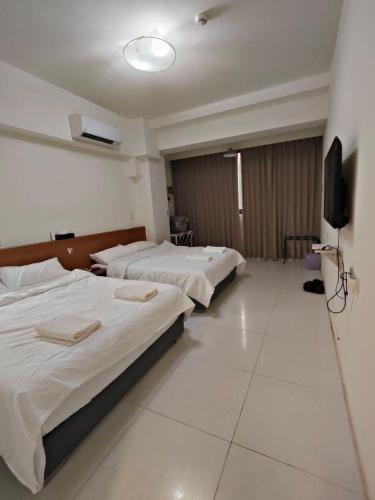 a hotel room with two beds and a flat screen tv at 馥芯莟旅棧 in Nangan Airport