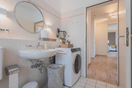 a bathroom with a sink and a washing machine at Rentaflat Hamburg 01 am Bahnhof in Norderstedt