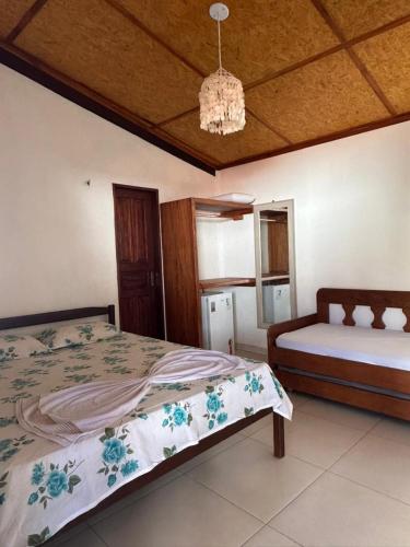 a bedroom with two beds and a chandelier at Flechimar Suítes in Trairi