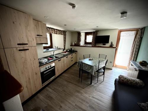 a kitchen with a table and a dining room at La maison du faux monneyeur in Saint-Rhémy-en-bosses