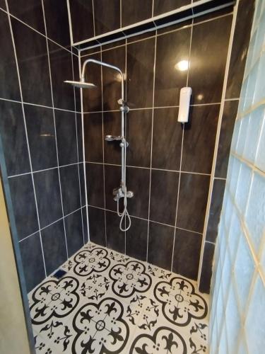 a bathroom with a shower with black and white tile at Gölyaka Hotel in Bursa