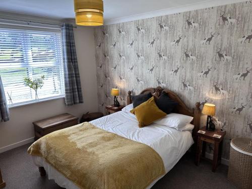 a bedroom with a bed and a wallpaper with dogs on it at Bon Accord in Fort Augustus
