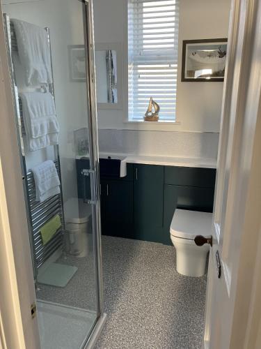 a bathroom with a toilet and a glass shower at Bon Accord in Fort Augustus