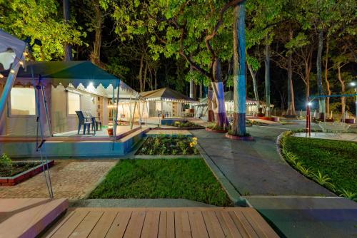 a garden at night with a tent and a pond at Forest Safari Retreat in Ganeshgudi