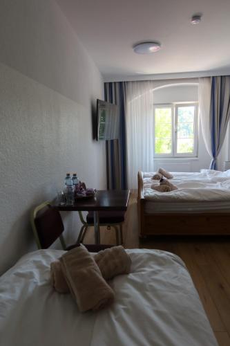 a hotel room with two beds and a table and a window at La Veneziana Guesthouse in Aschach an der Donau