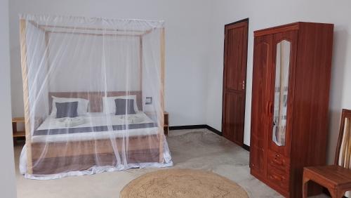 a bedroom with a bed with a canopy at Maku House in Makunduchi