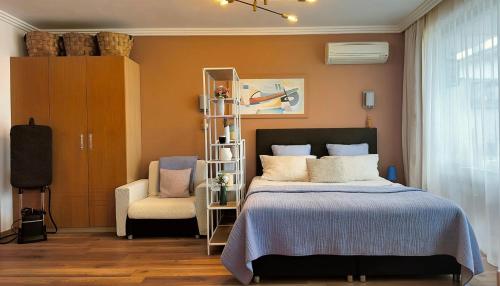 a bedroom with a bed and a chair at Emerald Breeze Studio in Hotel SPA Resort Emerald in Ravda