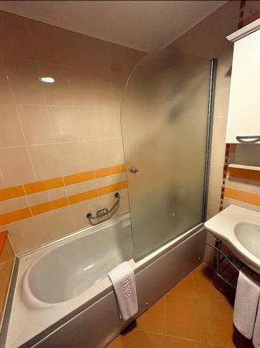 a bathroom with a bath tub and a sink at Emerald Breeze Studio in Hotel SPA Resort Emerald in Ravda