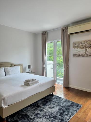 a bedroom with a bed and a large window at Entire 3BR Townhome in Sukhumvit, shared Pool, near BTS&MRT Asok in Bangkok