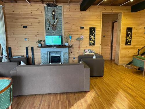 a living room with couches and a fireplace with a laptop at Omaya Hills in Nuwara Eliya
