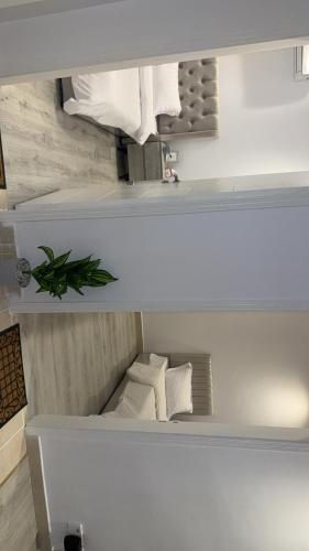 two views of a white room with a bed at شقة بالكامل حي المعذر 2 in Riyadh