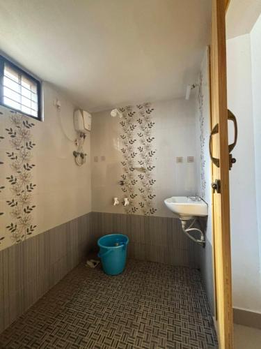 baño con lavabo y cubo azul en Yes Hostel Varkala - Black Beach Road, en Varkala