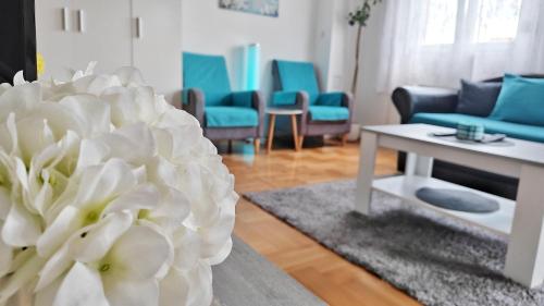 a living room with a table and a white flower at Dream Rental Pirot Apartman in Pirot