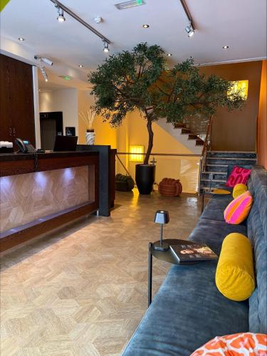 a living room with a couch and a tree at Boutique Hotel Lumiere in Eindhoven