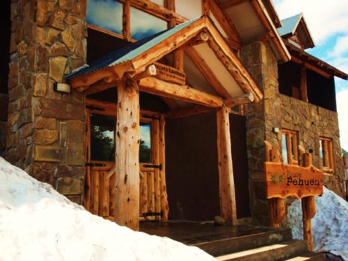 a entrance to a log cabin in the snow at Ruca Pehuen Eco-Lodge De Montaña in Caviahue