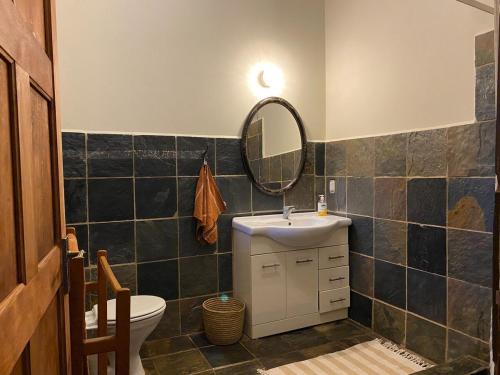 a bathroom with a sink and a mirror and a toilet at Casa Miramare - Marina Beach in Southbroom