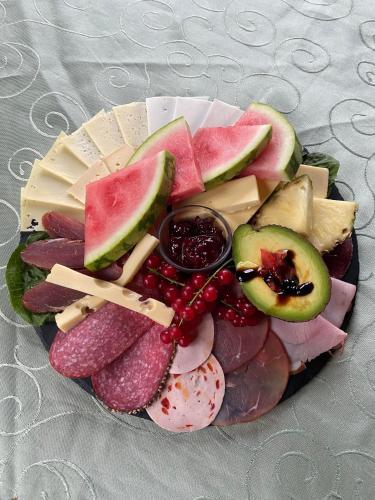 a plate of food with meat cheese and fruit at Pension Waldfrieden in Thale