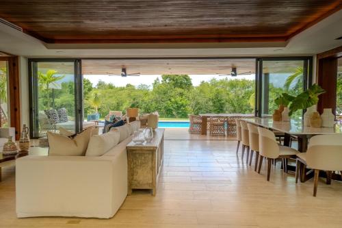 a living room with a white couch and a table at Villa Libertad, amazing pool ,modern design in El Infiernito